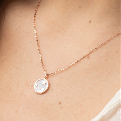 Rose gold moon and star pendant necklace close-up with round locket