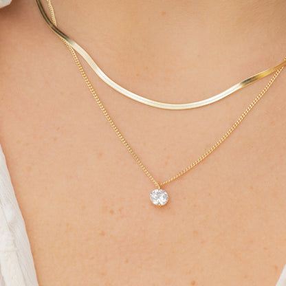 Double-layer snake chain necklace with light and gold-tone chains and round crystal pendant