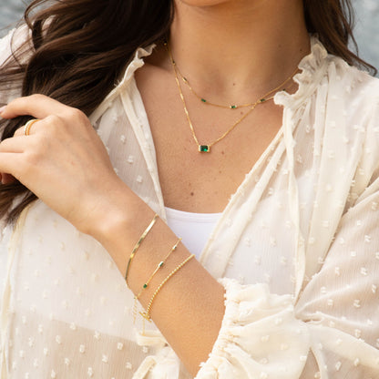Gold emerald pendant necklace with small green square pendant on chain
