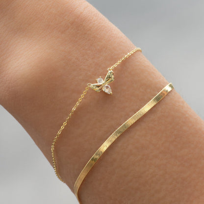Firefly bracelet with gold-tone chain and bow-and-flower charm