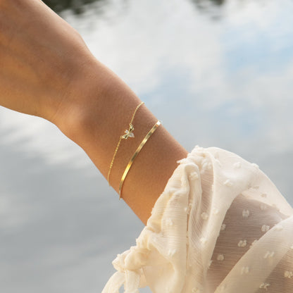 Firefly bracelet with gold-tone chain charm and wide cuff on wrist
