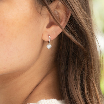 Silver heart charm huggy hoop earrings with textured pavé heart charm