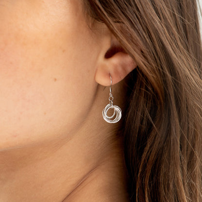 Silver hoop charm earrings with triple ring drop detail