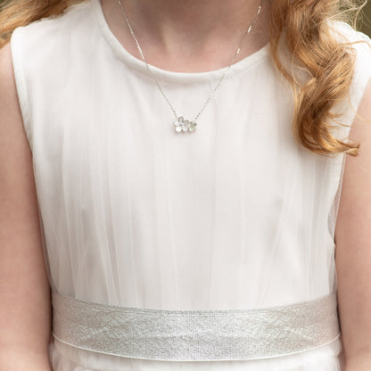 Flower pendant necklace on model, with small star charm at neckline