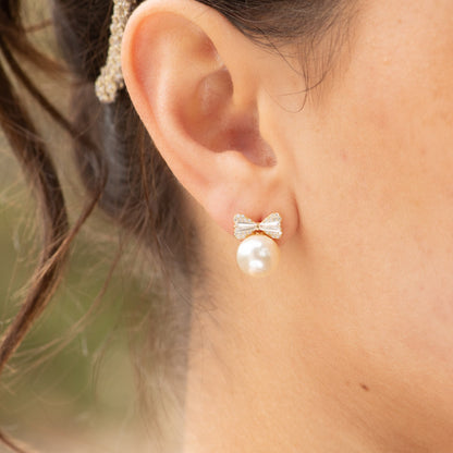 Gold-tone bow stud earrings with rhinestone bow and white pearl