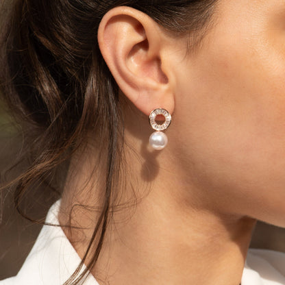 Rose gold round crystal earrings with white pearl drop on ear