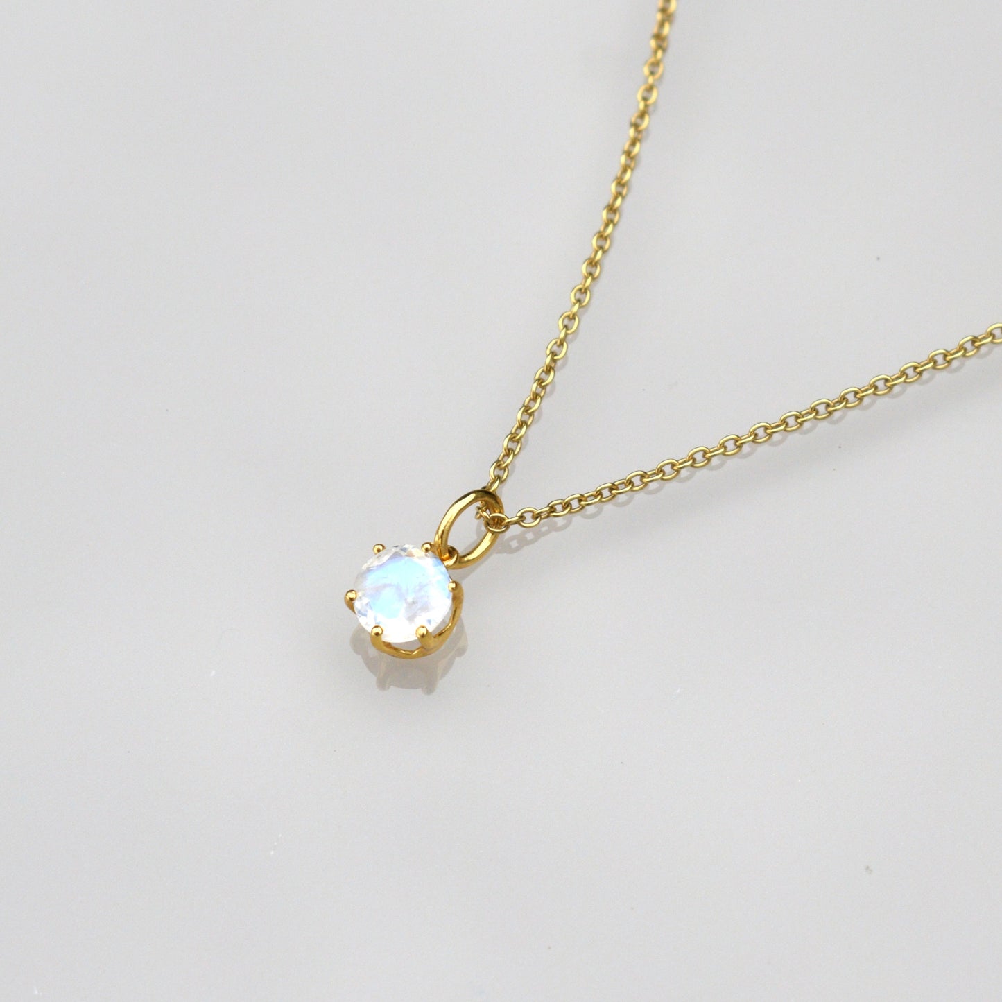 June birthstone necklace with gold chain and round iridescent moonstone pendant