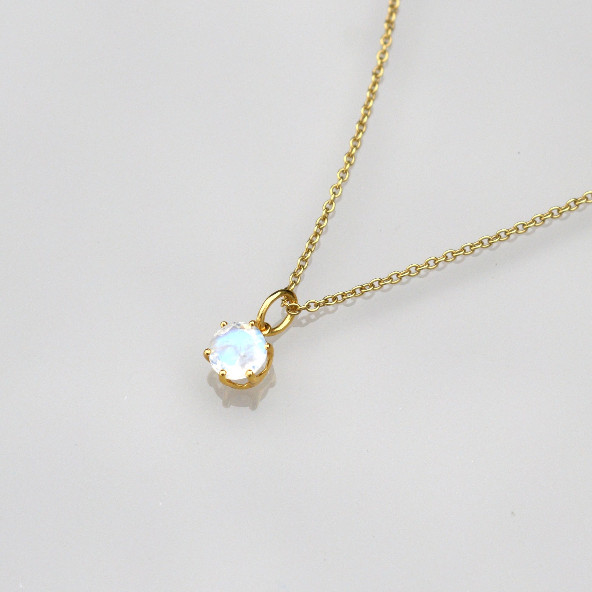 June birthstone necklace with gold chain and round iridescent moonstone pendant
