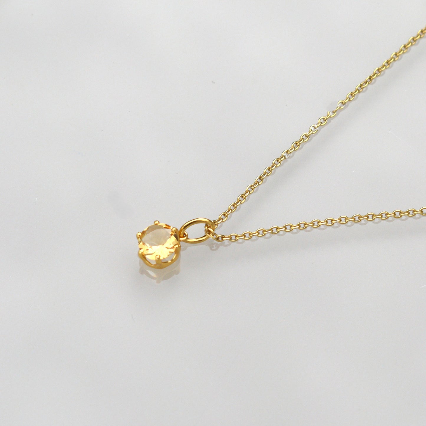 Gold-tone chain necklace with round citrine gemstone pendant on thin links