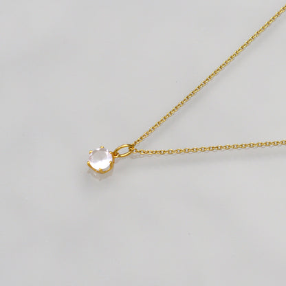 Gold-tone necklace with round rose quartz-style pendant on a fine chain
