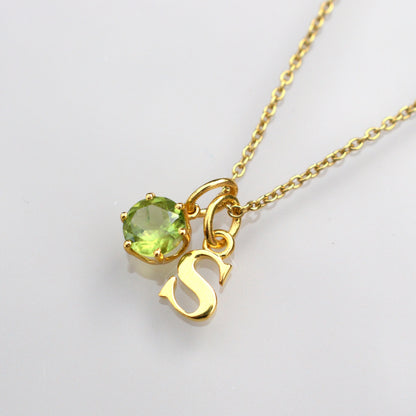 Peridot gemstone necklace with round green stone and heart charm on gold-tone chain