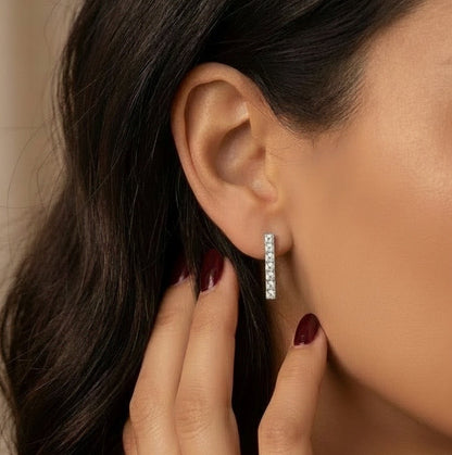 Crystal tennis bar drop earrings on model’s ear, silver-toned rectangular stones