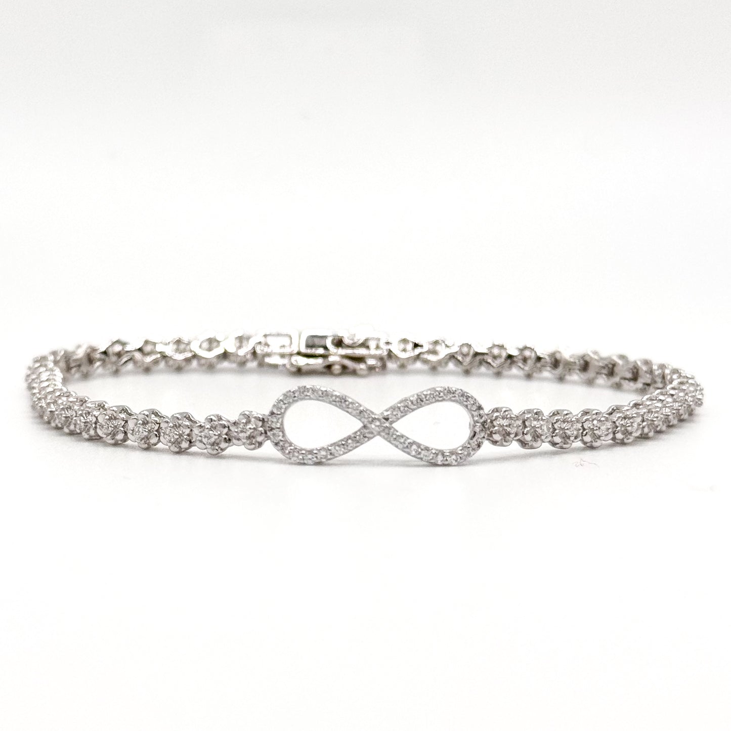 Silver infinity bracelet with crystal tennis links and an infinity symbol charm.