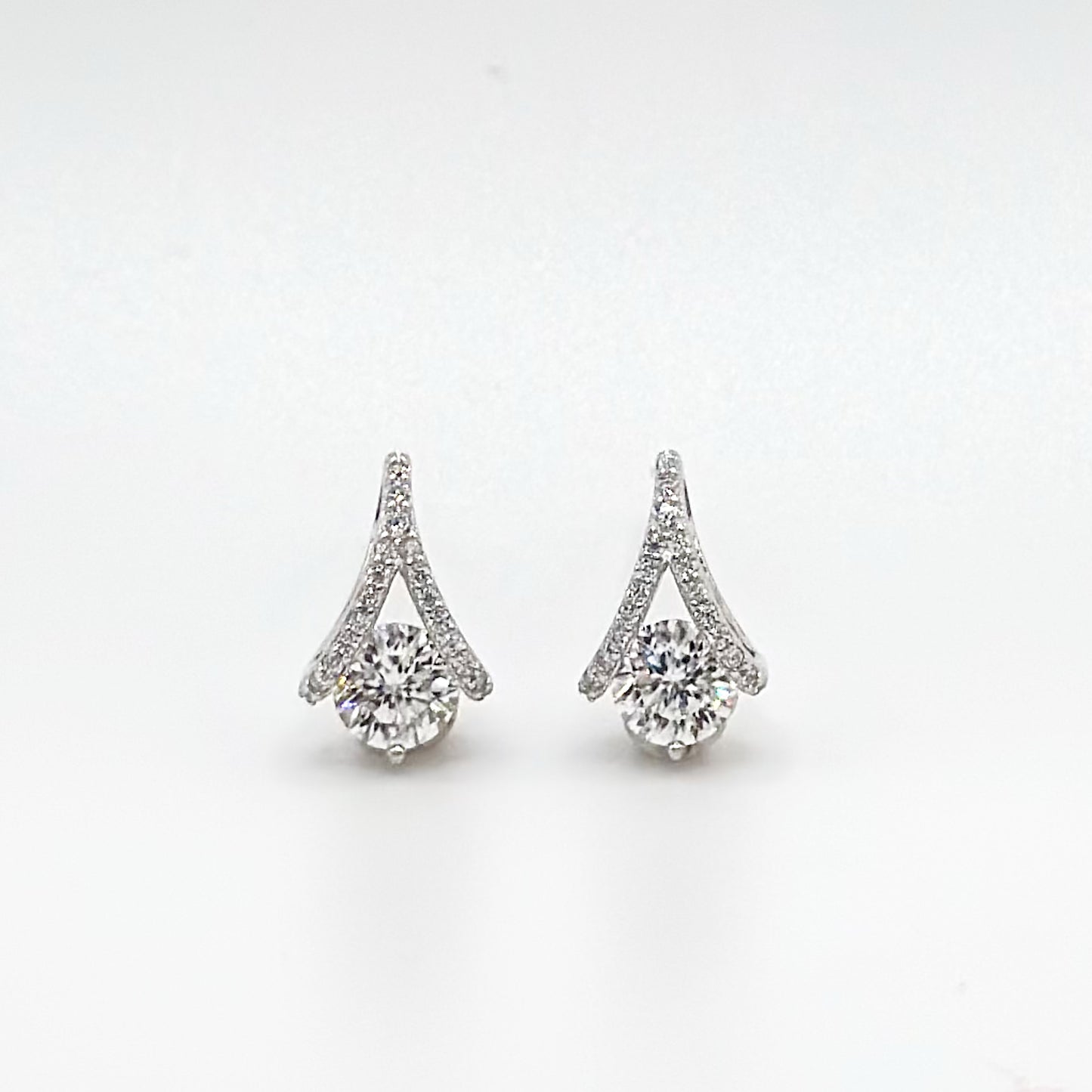 Teardrop diamond stud earrings with prong-set stones, halo and tapered top.