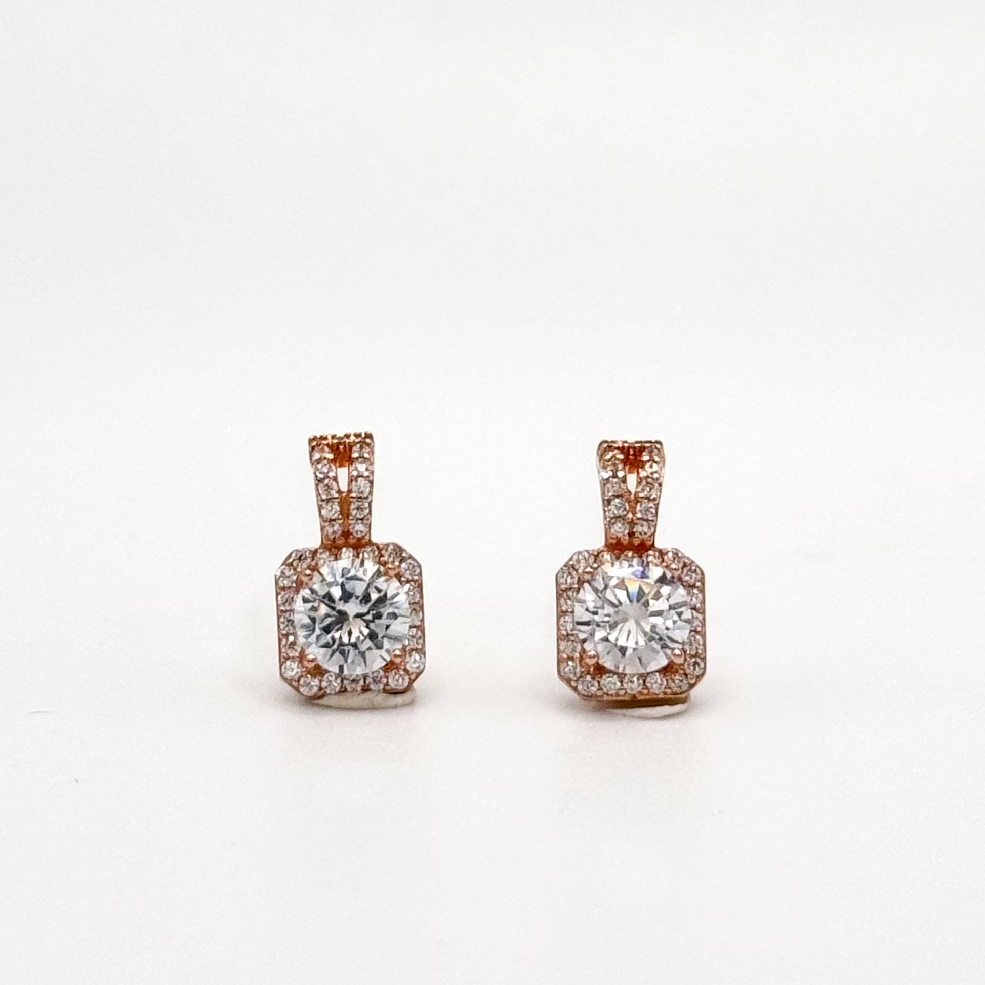 Rose gold square stud earrings with round center stone and jeweled square border.