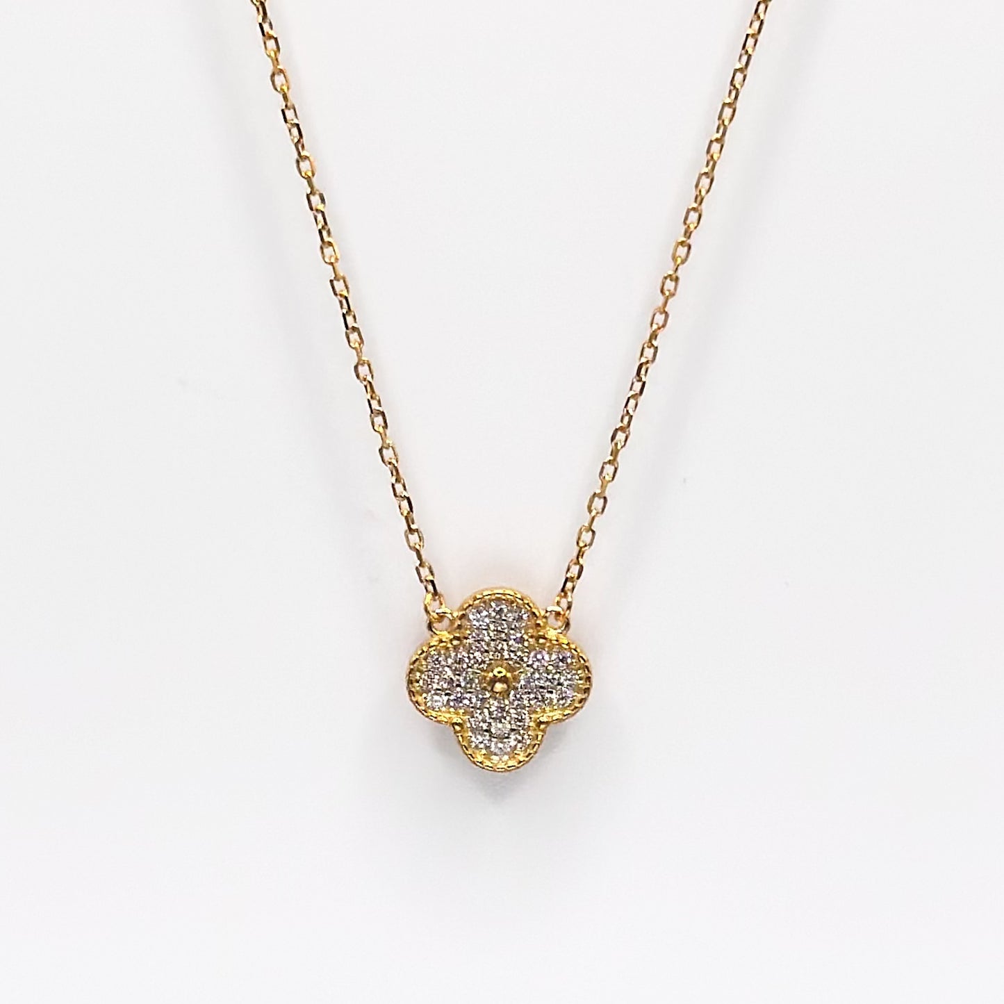 Gold four-leaf clover pendant necklace with glittery charm on chain