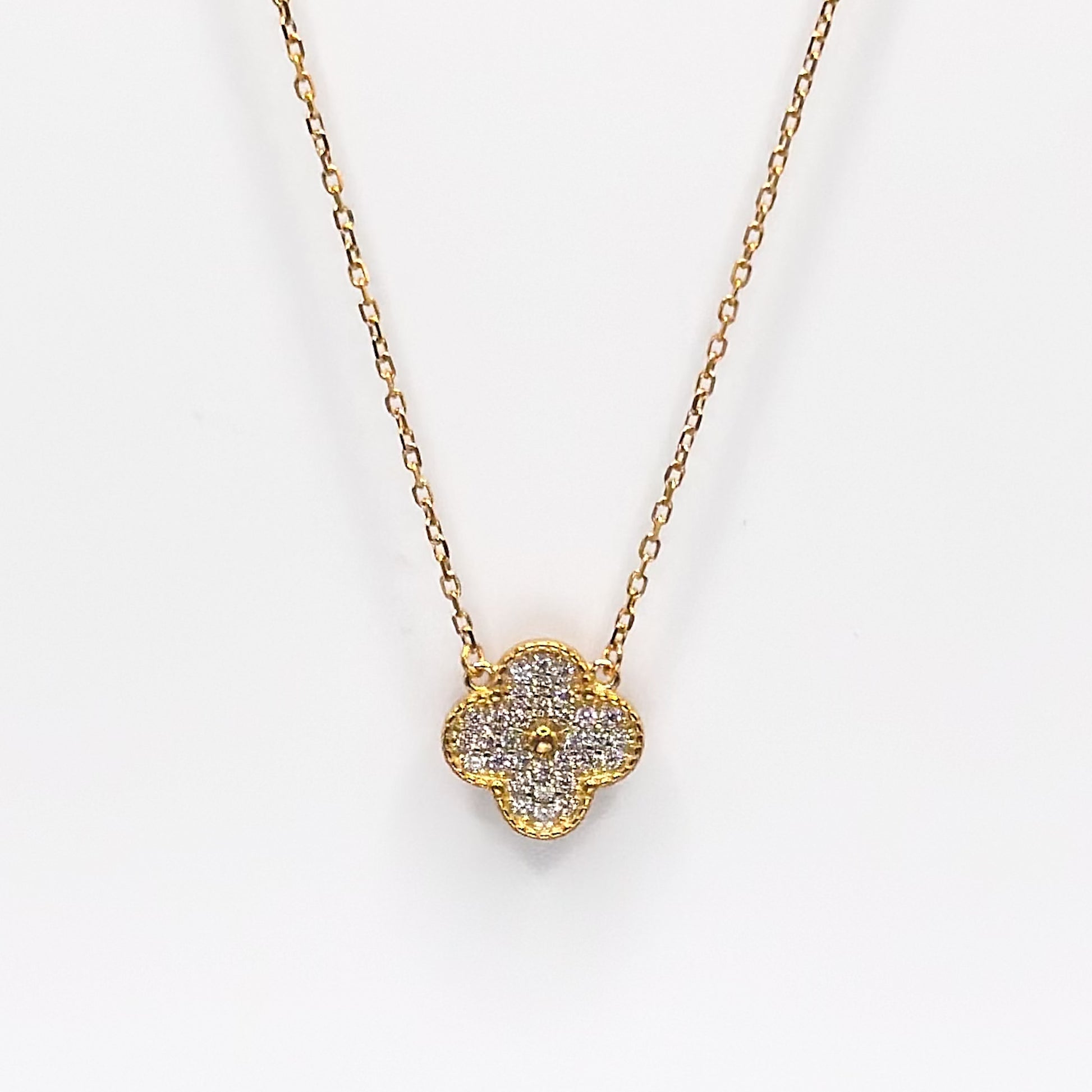 Gold four-leaf clover pendant necklace with glittery charm on chain