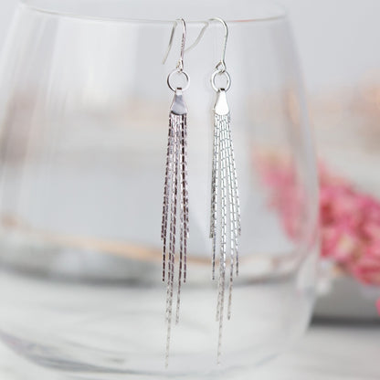 Silver tassel fringe earrings with circular tops and long dangling chain strands