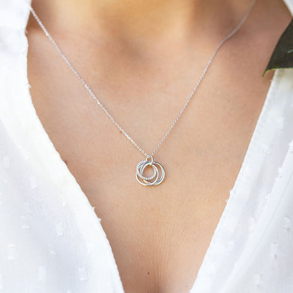 Silver ring pendant necklace with a circular four-ring charm on a fine chain