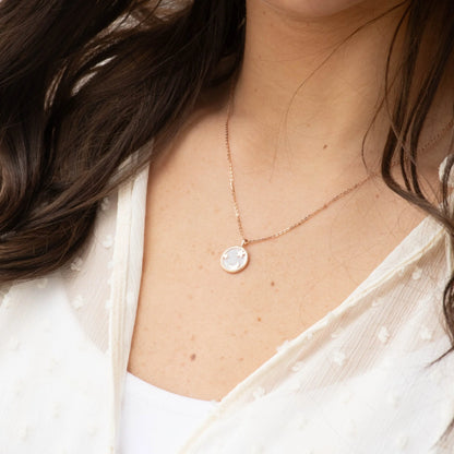Rose gold moon and star pendant necklace worn at the collarbone
