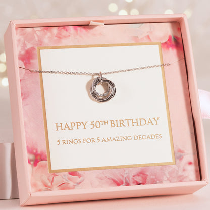 Silver ring-pendant necklace on card inside pink gift box