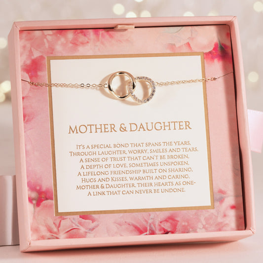 Bracelet with interlocking rings in a decorative box with floral design and sentimental message for mother and daughter.