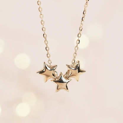Gold-tone chain necklace with three stacked star pendants