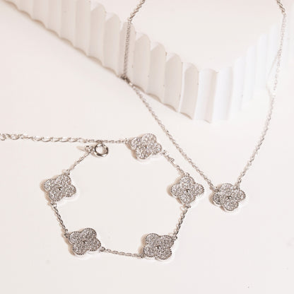 Sterling silver clover bracelet with sparkling clover charms and chain, flat view.