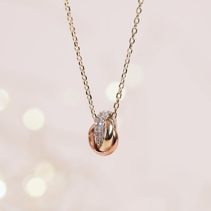 Gold chain knot pendant necklace with oval center set in pavé