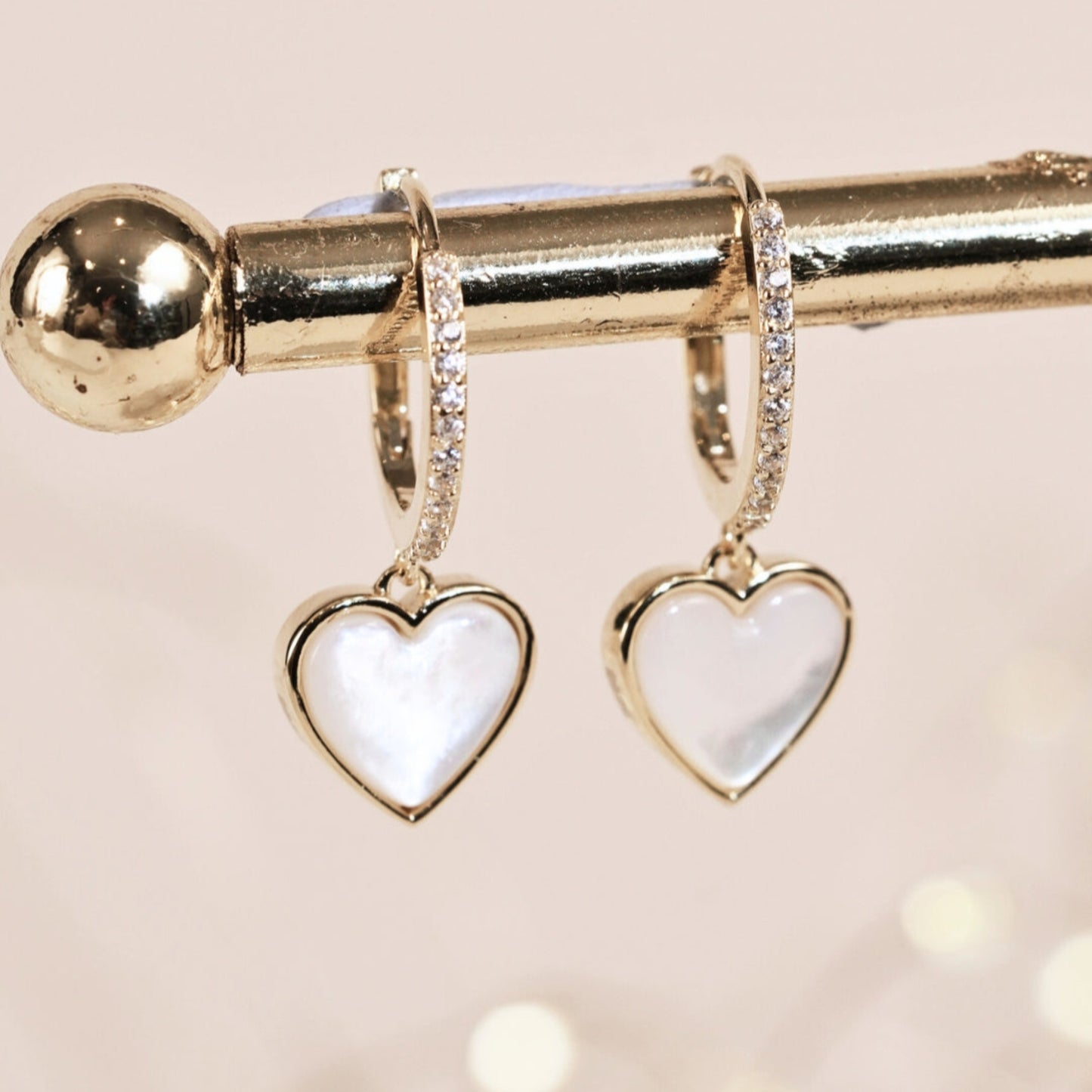Heart-shaped huggie hoop earrings on a light background