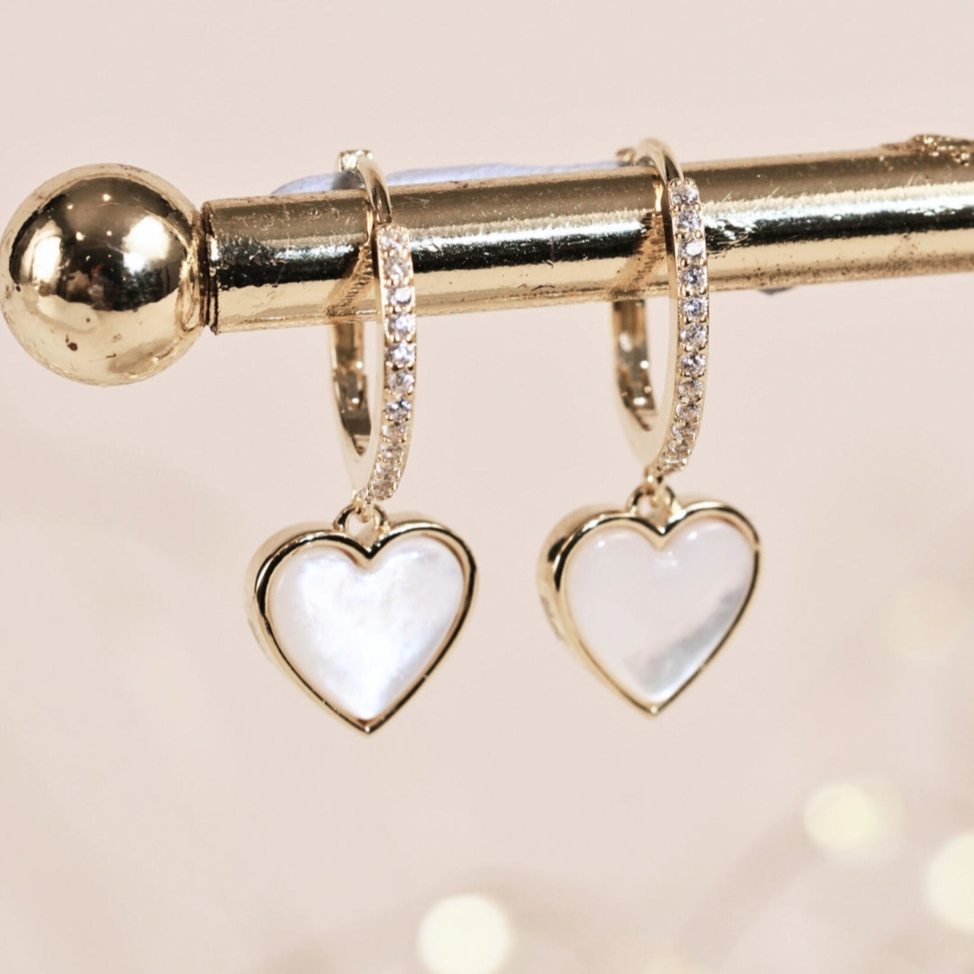 Heart-shaped huggie hoop earrings on a light background