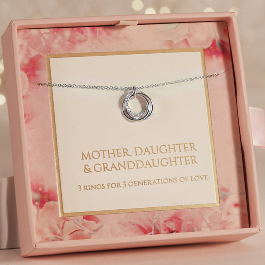 Necklace with a pendant in a pink jewelry box with a card reading 'Mother Daughter & Granddaughter'.