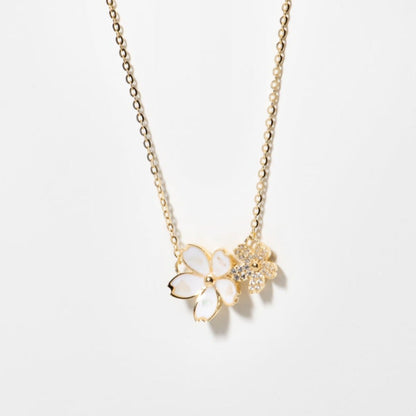 Gold flower necklace with four-petal pendant and glittery star accent
