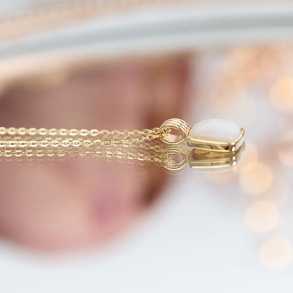 Gold clasp detail on pendant necklace with square mother-of-pearl charm
