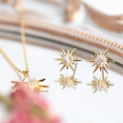 Gold starburst crystal stud earrings set with round clear center stones