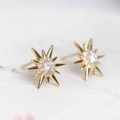 Gold starburst crystal stud earrings with round clear center stone