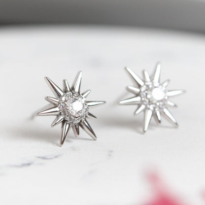 Silver starburst crystal stud earrings with round clear center stones