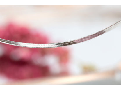 Silver flat snake chain bracelet close-up of interlocking links