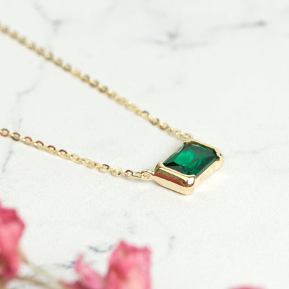 Gold emerald pendant necklace with green square gemstone pendant close-up