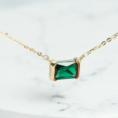 Gold emerald pendant necklace with green square-cut gemstone set in bezel