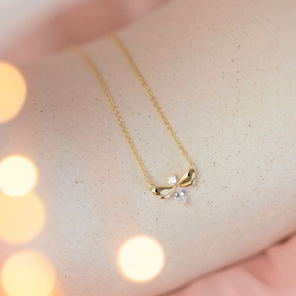 Gold firefly pendant necklace with wing motif and clear teardrop stone on chain