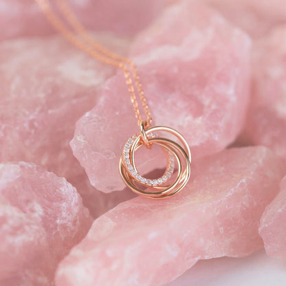 Rose-gold 4-ring pendant necklace with small stone detail, circular stacked rings charm