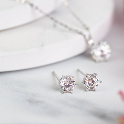 Round lab-grown diamond stud earrings in four-prong settings, white metal, close-up