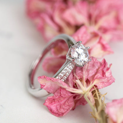 Silver lab-grown diamond ring with oval center stone and prong-set pave band
