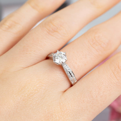 Silver lab-grown diamond ring on hand, oval center stone with pave sides