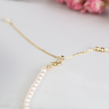 Gold-tone clasp and adjustable chain with white pearl end detail on choker