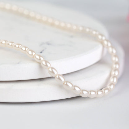 White pearl choker necklace with glossy round pearl beads, close-up