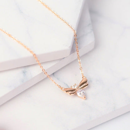 Rose gold firefly pendant necklace with wing motif and clear teardrop crystal