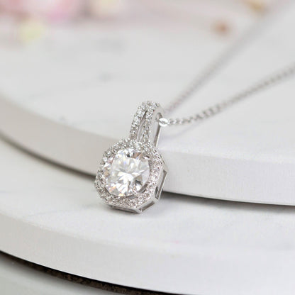 Lab-grown moissanite pendant necklace close-up, round stone halo bezel, silver chain