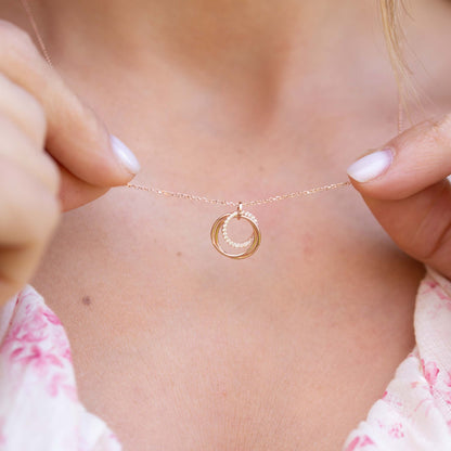 Gold rings necklace with small circular interlocking ring pendant